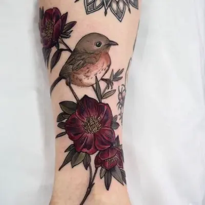 Tatuaggio a colori con un uccello, fiori e foglie